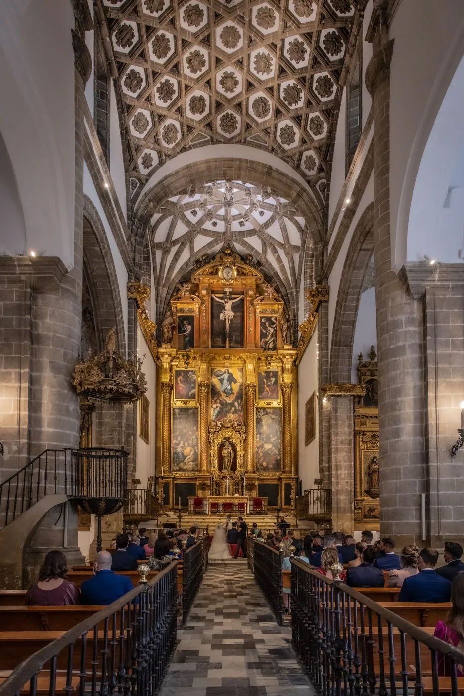 Vista desde la entrada hacia el altar de iglesia de Nuestra Señora de la Oliva. El Sí Quiero de de Melissa y Alejandro. Fotógrafo profesional de bodas en Sevilla. Fotos de boda en Lebrija, Andalucía 