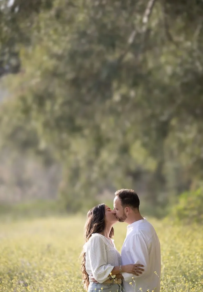 Pareja abrazándose en un campo de flores en primavera, sesión preboda en Arcos de la Frontera Cádiz