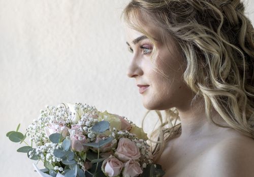 Novia con ramo de flores preparándose para su boda