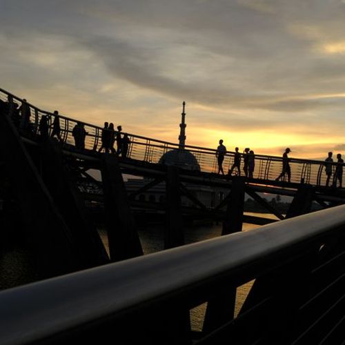 Partial view of the Darul Hana bridge at sunset with the minaret of the floating mosque behind